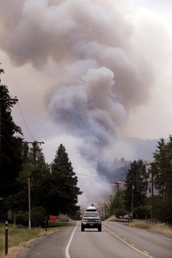 Smoke rises in the distance near Carlton, Washington. A wildfire in rural north-central Washington destroyed homes. 