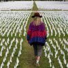 Artist Suzanne Brennan Firstenberg walks among thousands of white flags planted in remembrance of Americans who have died of COVID-19.