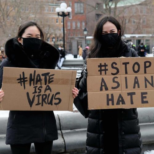  Protestors hold signs at the End The Violence Towards Asians rally in New York City. 