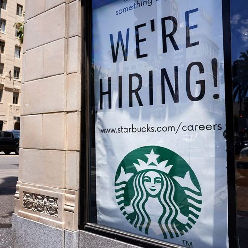  A 'We're Hiring!' sign is displayed at a Starbucks. Wages rose across all racial groups in the first 3 months of 2021. 