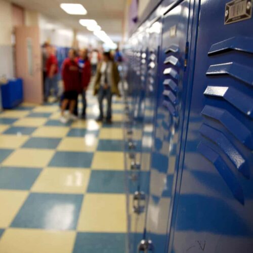  A look at a school hallway as students gather around lockers. 