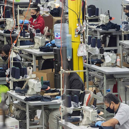  Several workers in the garment industry sew masks to meet the coronavirus demand. 