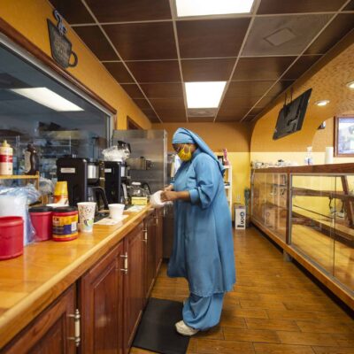 Tahiyyah Muhammad cleans behind the counter of Shabazz Bakery and Coffee Shop.